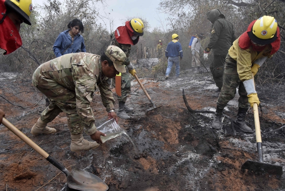  Soldiers, firemen and volunteers combat forest fires in the surroundings of Robore in eastern Bolivia, on Sunday. -AFP
