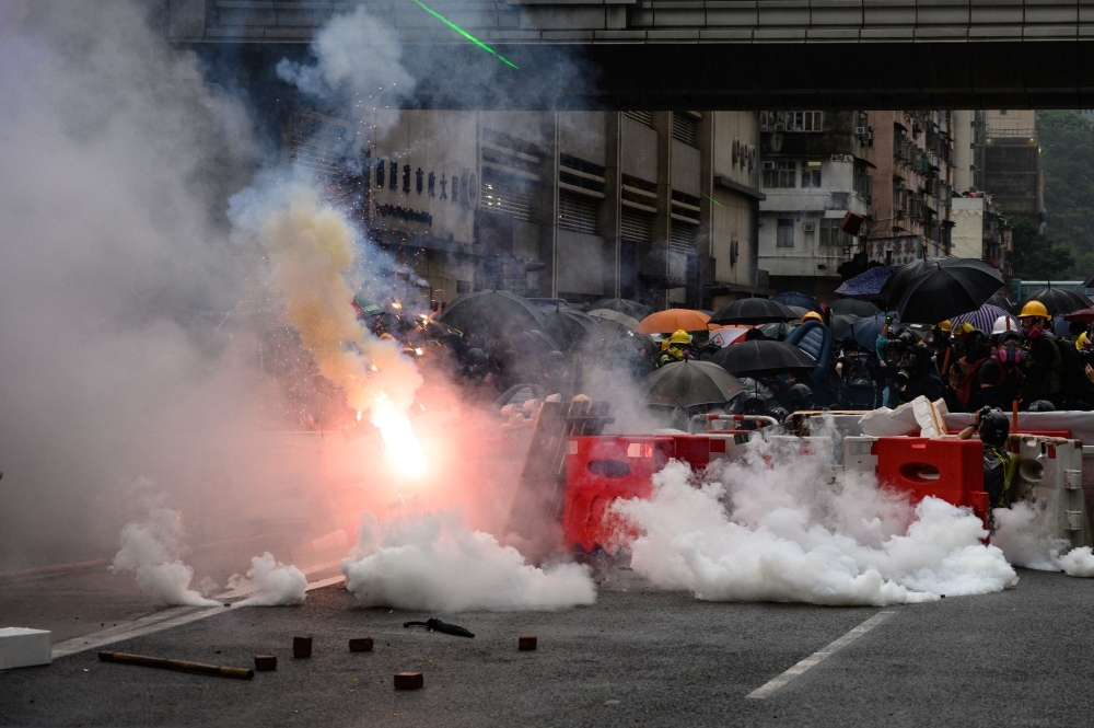 Police fire tear gas during a protest in Tsuen Wan district of Hong Kong on Sunday. -AFP