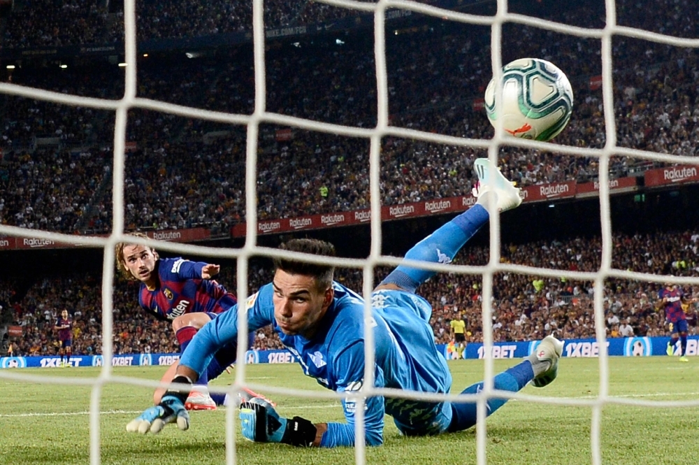 Barcelona's French forward Antoine Griezmann (L) scores against Real Betis' Spanish goalkeeper Daniel Martin during the Spanish League football match between Barcelona and Real Betis at the Camp Nou stadium in Barcelona, on Sunday. — AFP