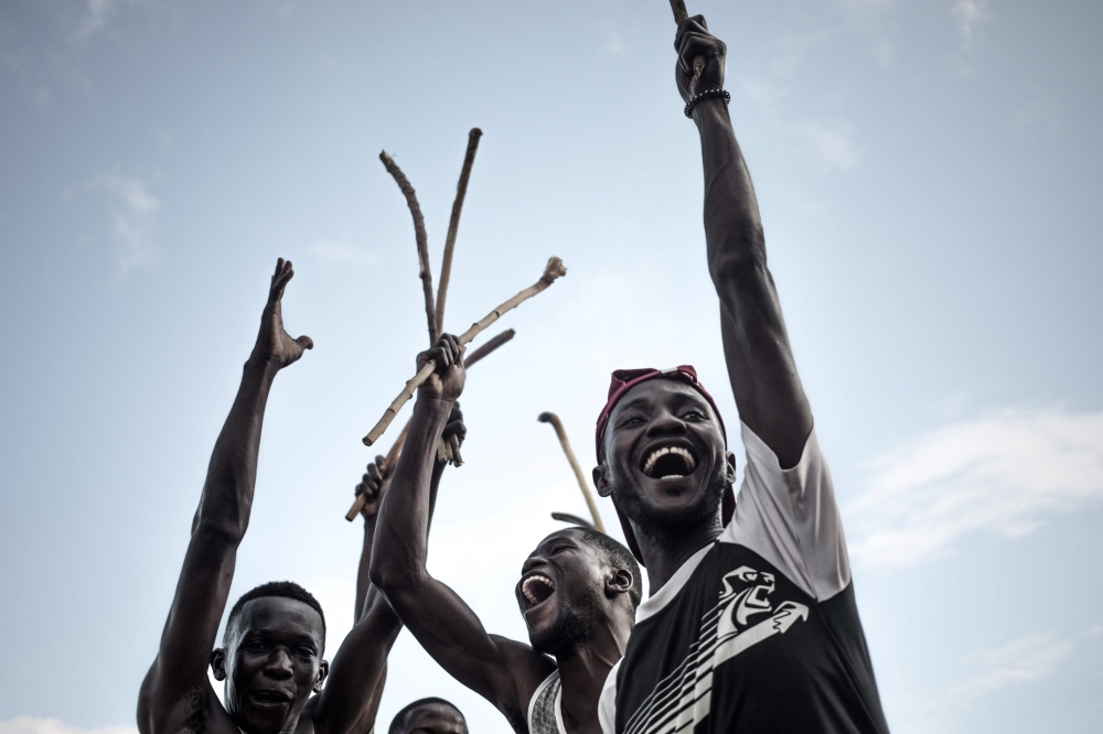 Ngbaba players hold wooden sticks before a game in Bangui, on August 8, 2019. -AFP