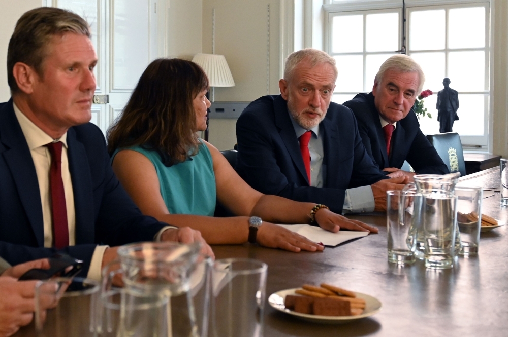 Britain's opposition Labour Party leader, Jeremy Corbyn, second right, sits with members of his shadow cabinet as they pose for a photograph while preparing to meet with leaders of Britain's other political parties to discuss options for Brexit, in Portcullis House, central London, on Tuesday. — AFP
