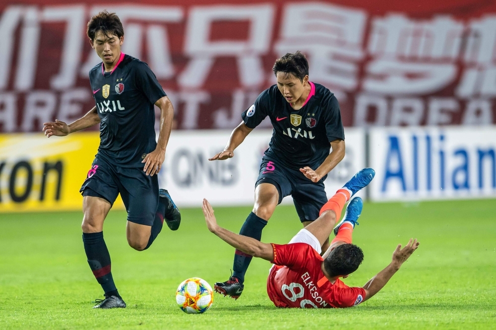 Elkeson (R) of China's Guangzhou Evergrande falls as he fights for the ball with Jung Seung-Hyun (C) of Japan's Kashima Antlers during their AFC Champions League quarterfinal football match in Guangzhou in China's southern Guangdong province on Wednesday. — AFP