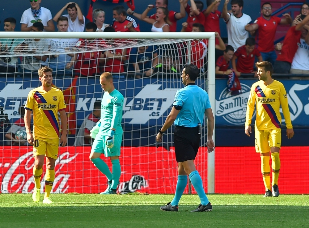 (FromL) Barcelona's Spanish midfielder Sergi Roberto, Barcelona's German goalkeeper Marc-Andre Ter Stegen and Barcelona's Spanish defender Gerard Pique react after Osasuna's Spanish midfielder Roberto Torres scored a goal during the Spanish league football match at El Sadar stadium in Pamplona on Saturday. — AFP