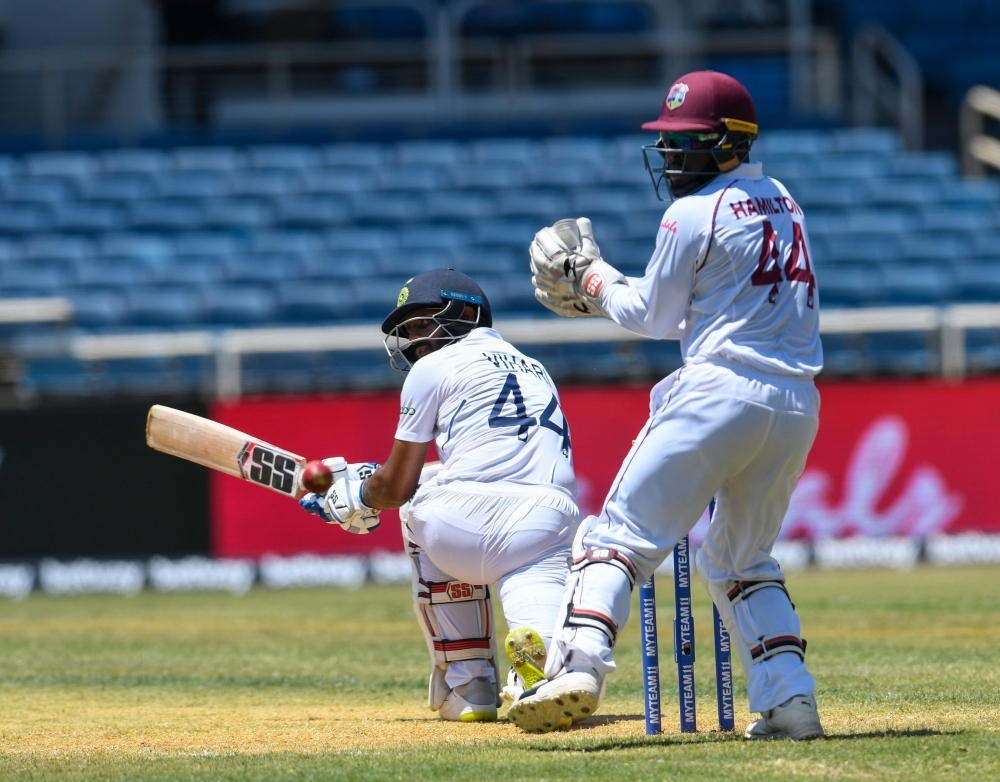Hanuma Vihari (L) of India hits past Jahmar Hamilton (R) of West Indies during day 2 of the 2nd Test between West Indies and India at Sabina Park, Kingston, Jamaica, on Saturday. — AFP