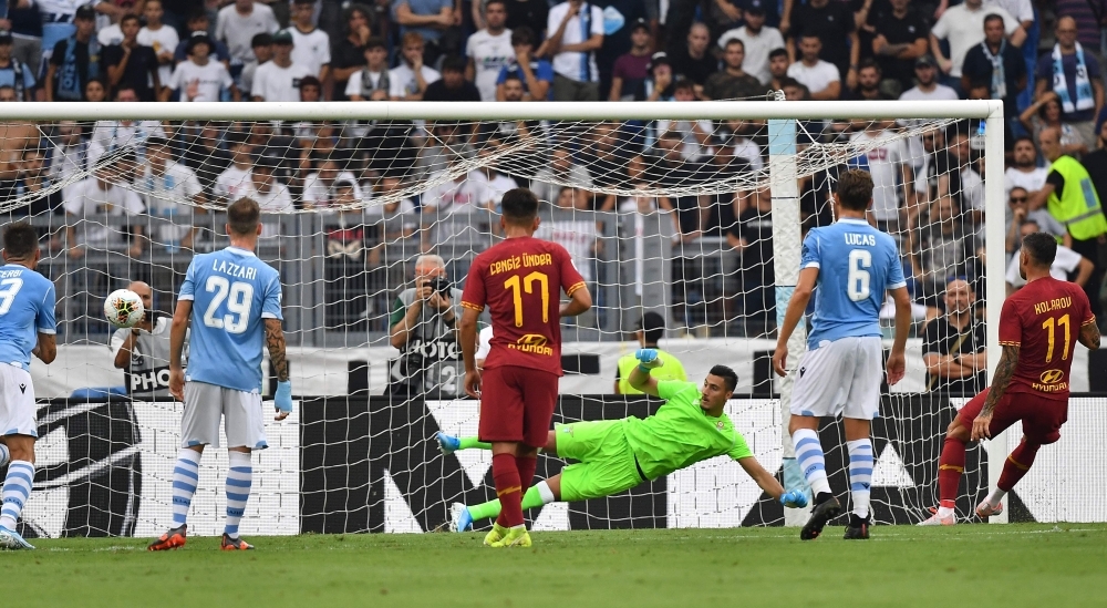 AS Roma's Serbian defender Aleksandar Kolarov (R) scores a penality in front of Lazio's Albanian goalkeeper Thomas Strakosha during the Italian Serie A football match between Lazio Roma and AS Roma on Sunday at the Olympic stadium in Rome. — AFP