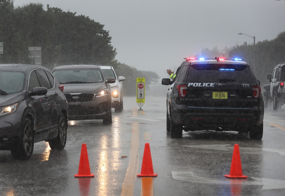 A Highland Beach police officer sits in his vehicle to check id's of people in cars as he only allows residents to enter the Highland Beach area as Hurricane Dorian continues to make its way toward the Florida coast in Highland Beach, Florida, on Monday. — AFP
