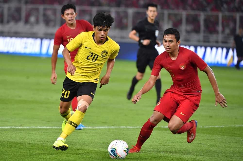 Malaysia's Muhammad Syafiq Ahmad (R) celebrates after scoring a goal during FIFA world cup preliminary qualification round 2 at the Gelora Bung Karno stadium di Jakarta on Thursday. — AFP 