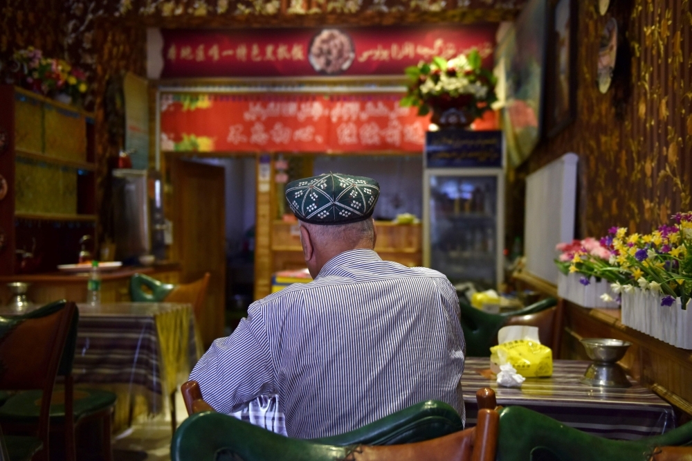 A Uighur man sits in a restaurant in Hotan in China's northwest Xinjiang region in this May 30, 2019 file photo. — AFP