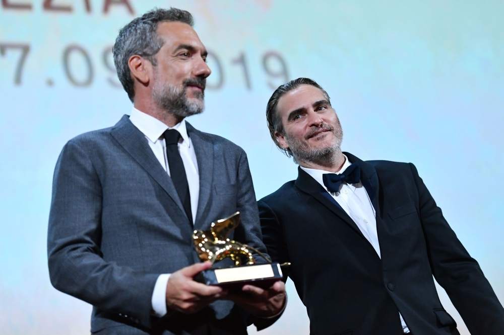 US director Todd Phillips (L), flanked by US actor Joaquin Phoenix, holds the Golden Lion award for Best Film he received for the movie 