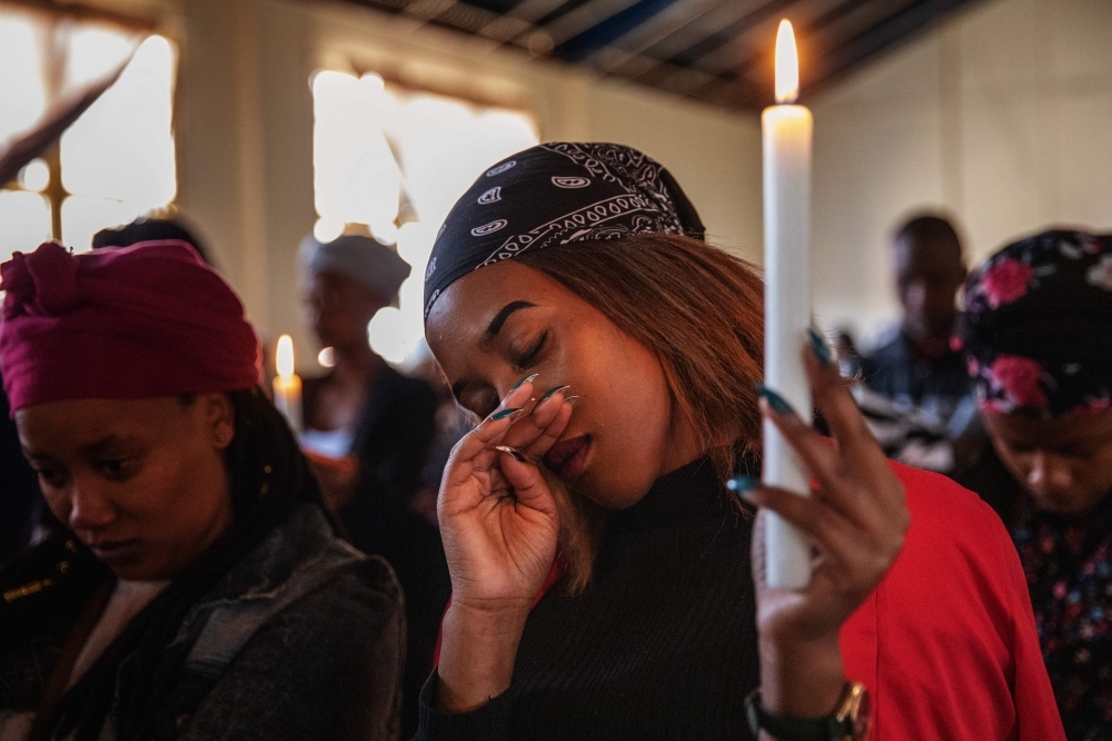 A woman holds a candle as she attends the joint memorial service of Keobakele Isaac Sebaku and Karabo Ditire in Coronationville, a low income suburb west of Johannesburg, on September 7, 2019, near where the two South African nationals were shot dead on September 3.   South Africa's financial capital was recently hit by a new wave of violence mostly targeting foreign nationals. -AFP