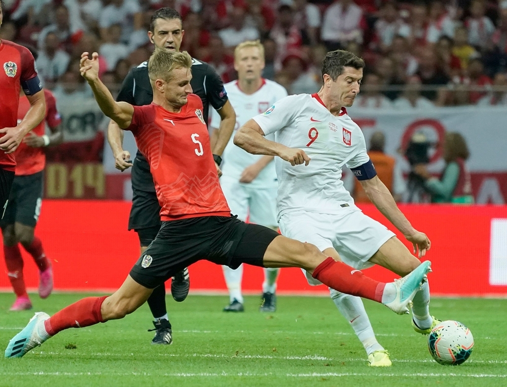 Poland's forward Robert Lewandowski and Austria's Defender Stefan Posch vie during the UEFA Euro 2020 Group G qualification football match Poland v Austria in Warsaw, Poland, on Monday. — AFP
