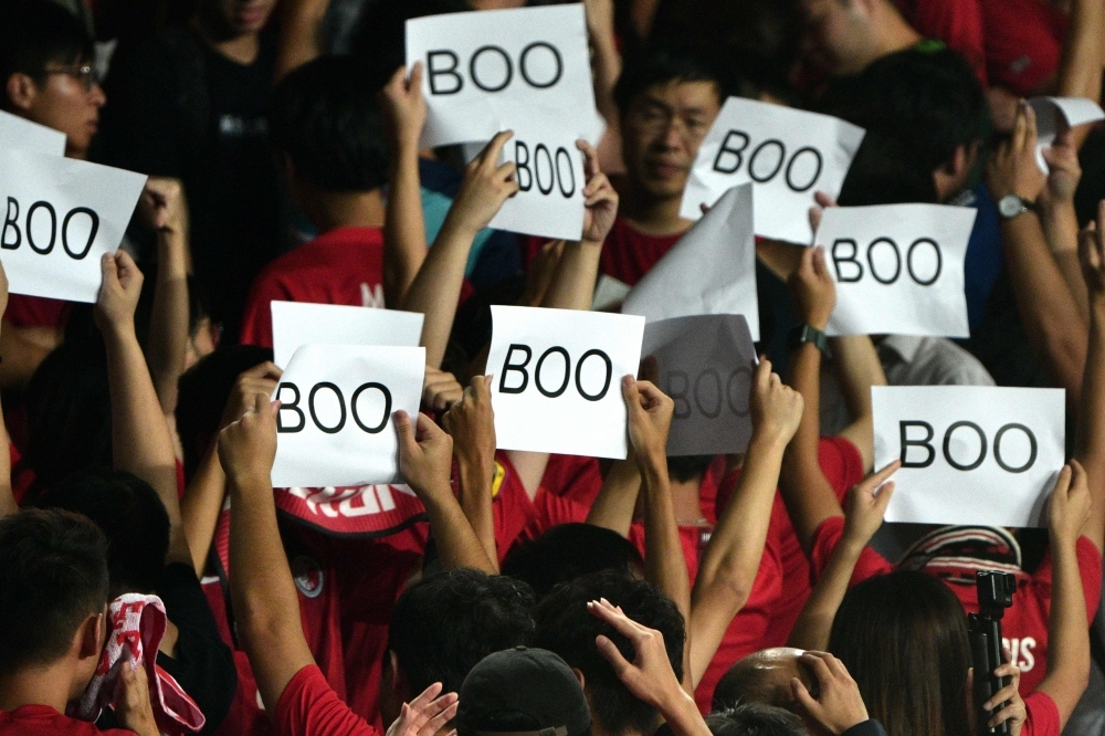 People turn their back and boo while holding up placards during the Chinese anthem at the start of the Qatar 2022 World Cup qualifying football match between Iran and Hong Kong at Hong Kong Stadium on Tuesday. -Courtesy photo
