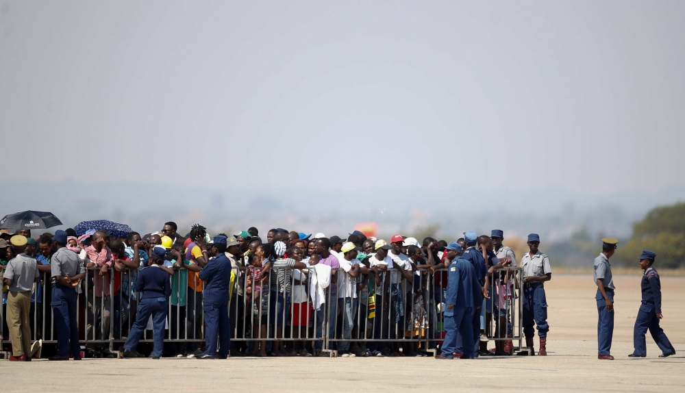 Zimbabweans wait for the arrival of the body of former Zimbabwean President Robert Mugabe in Harare, Zimbabwe, on Wednesday. — Reuters