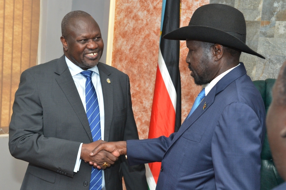 South Sudan's President Salva Kiir Mayardit, right, shakes hands with ex-vice president and former rebel leader Riek Machar before their meeting in Juba, South Sudan, on Wednesday. — AFP