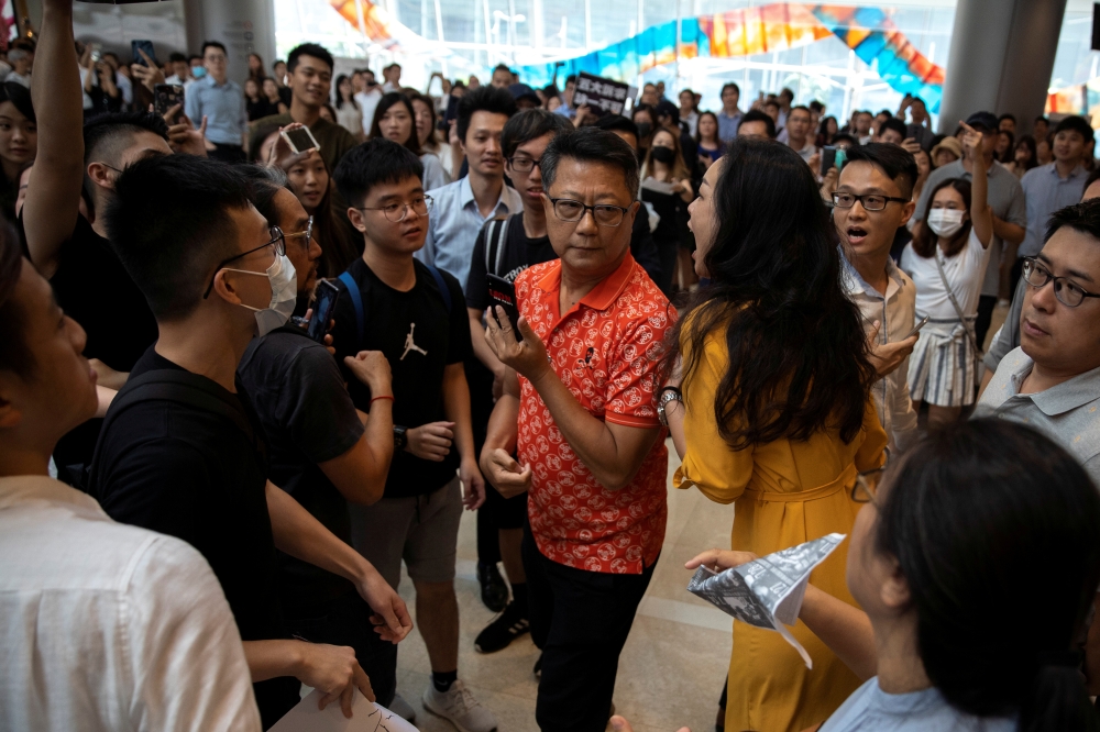 An anti-government protester yells at a pro-government supporter who is taking pictures of a flash mob style rally at a mall in Hong Kong, China, Thursday. — Reuters