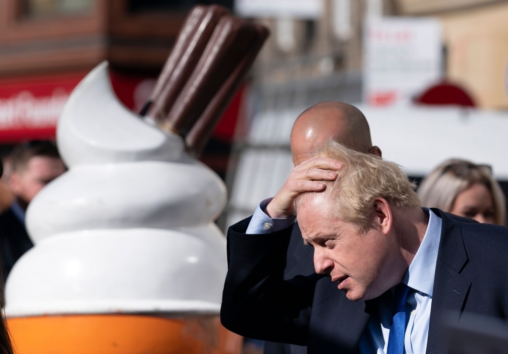 Britain's Prime Minister Boris Johnson, right, meets members of the public during his visits to Doncaster Market, in Doncaster, northern England, on Friday. — AFP