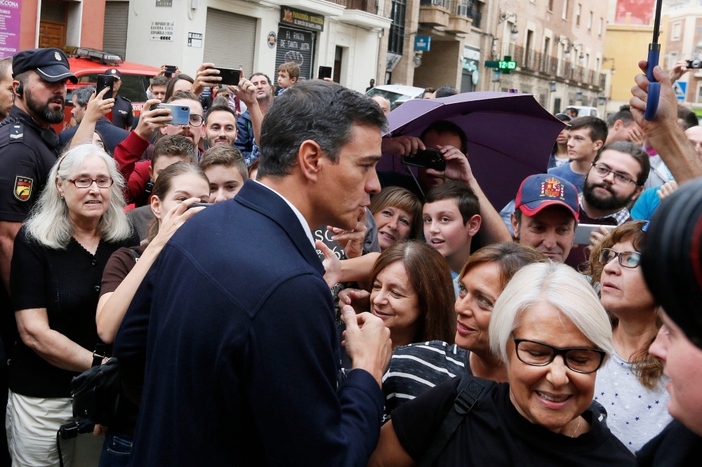 Spanish acting Prime Minister Pedro Sanchez (C) meets residents on Saturday in Orihuela. -AFP