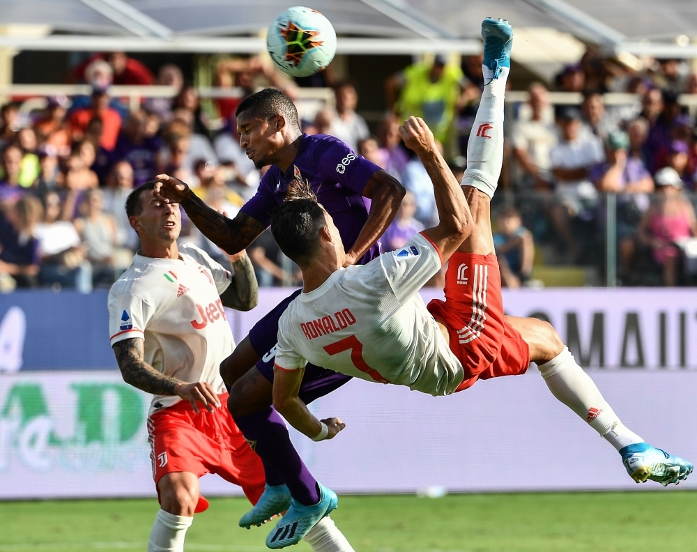 Juventus' Portuguese forward Cristiano Ronaldo performs an overhead kick despite Fiorentina's Brazilian defender Dalbert (Rear C) during the Italian Serie A football match Fiorentina vs Juventus at the Artemio-Franchi stadium in Florence, on Saturday. — AFP