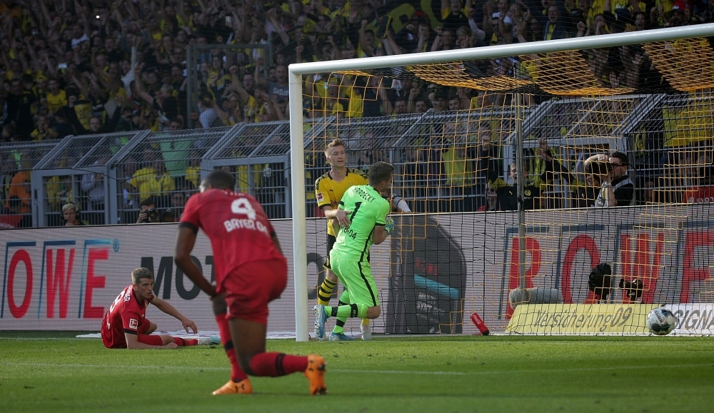 Dortmund's German forward Marco Reus (C) scores past Leverkusen's Finnish goalkeeper Lukas Hradecky during the German first division Bundesliga football match BVB Borussia Dortmund vs Bayer 04 Leverkusen in Dortmund, western Germany, on Saturday. — AFP