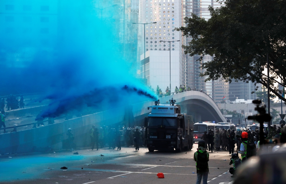 Police vehicle sprays blue-colored water towards anti-government protesters during a demonstration near Central Government Complex in Hong Kong on Sunday. -Reuters