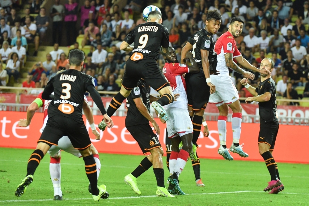 Olympique de Marseille's argentine forward Dario Benedetto heads the ball during the french L1 football match AS Monaco vs OM Marseille on September 15, 2019 at Louis II stadium in Monaco.  / AFP / YANN COATSALIOU
