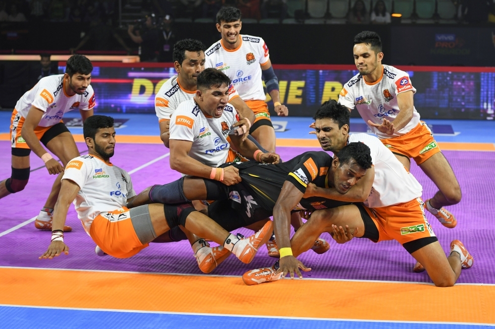 In this photograph taken on August 30, 2019, players of Puneri Paltan hold onto India's Siddharth Desai (C), raider of the Telugu Titans, during the match between Telugu Titans and Puneri Paltan in the Pro Kabaddi League at Thyagaraj Sports Complex in New Delhi. -AFP