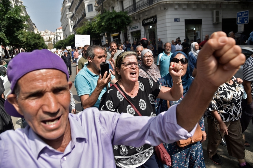 Algerian demonstrators chant slogans as they take part in a rally in the streets of the capital Algiers on Tuesday. — AFP