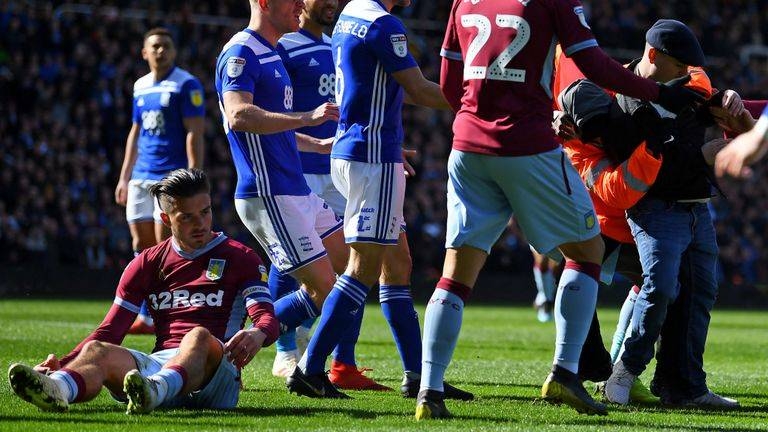 A fan is wrestled to the ground after punching Jack Grealish during the match between Birmingham City and Aston Villa at St Andrew's. — Courtesy photo