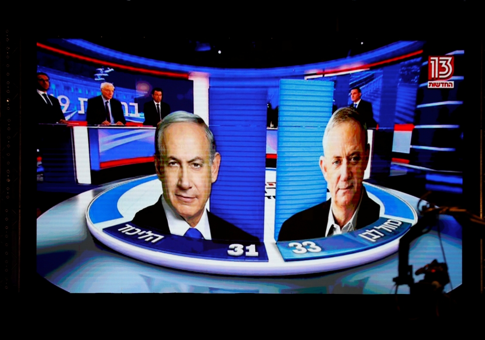 The results of the exit polls are shown on a screen at Benny Gantz's Blue and White party headquarters, following Israel's parliamentary election, in Tel Aviv, Israel, on Tuesday. — Reuters