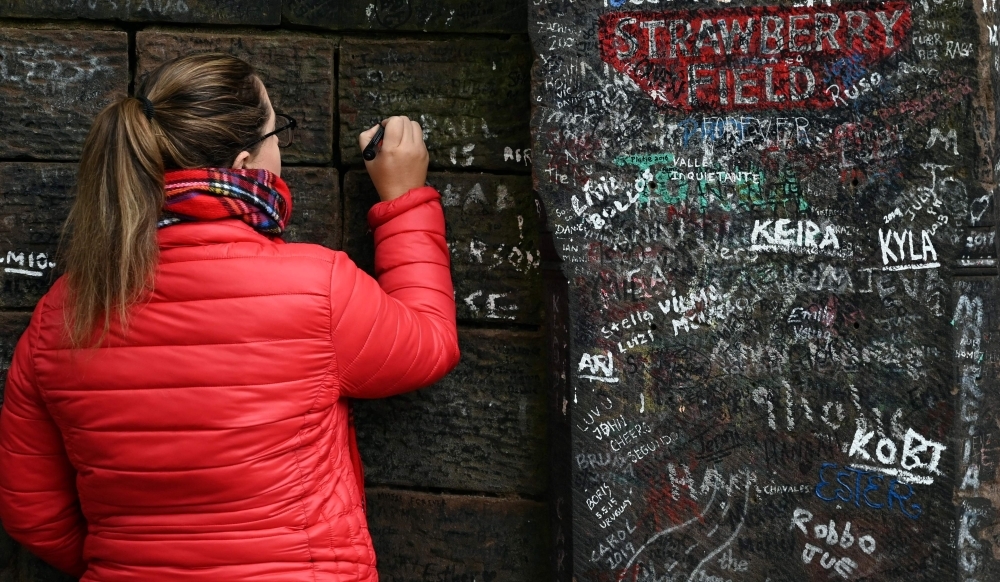 Graffiti is pictured on the gates to Strawberry Field in Liverpool, northwest England on Wednesday. Beatles fans can now take a trip through the childhood sanctuary of John Lennon that inspired seminal song 