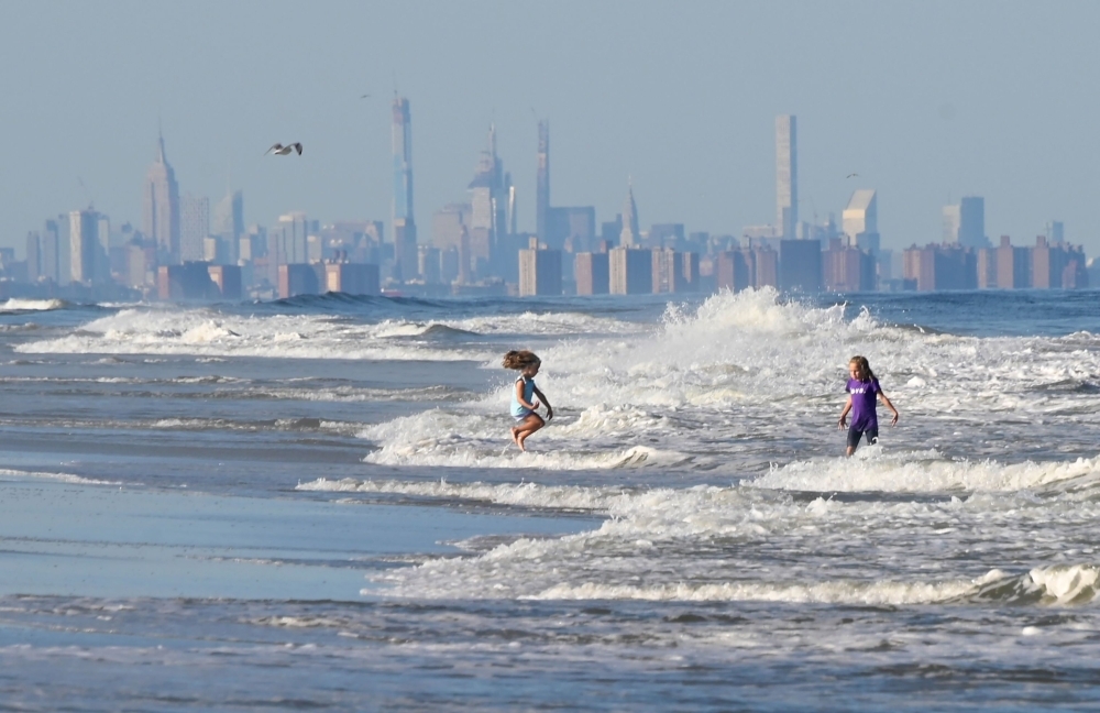 Children jump in the waves at the beach in front of the skyline of Lower Manhattan in Long Branch, New Jersey, in this Sept. 17, 2019 file photo. — AFP