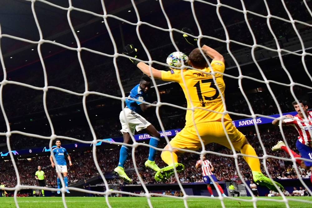 Juventus' French midfielder Blaise Matuidi (C) scores against Atletico Madrid's Slovenian goalkeeper Jan Oblak during the UEFA Champions League Group D football match  at The Wanda Metropolitano Stadium in Madrid, on Wednesday. — AFP
