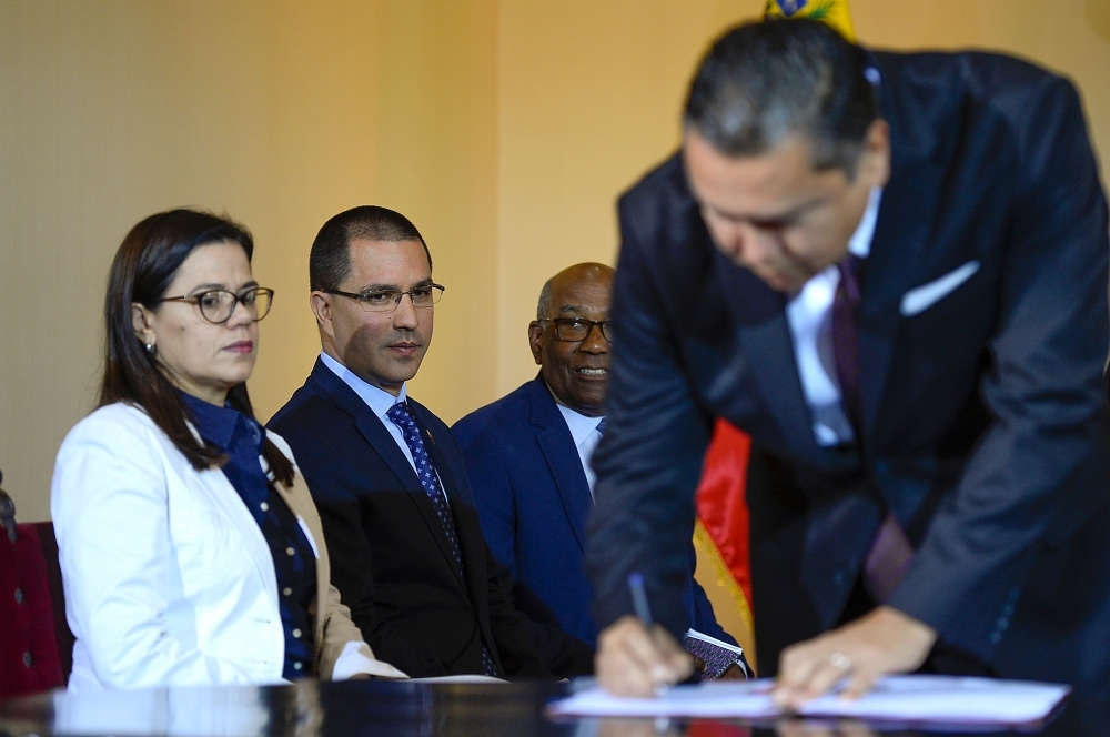 Venezuelan Foreign Minister Jorge Arreaza (2nd L) looks at opposition member Javier Bertucci during the signing of the dialogue agreement between the government and the opposition in Caracas on Wednesday. — AFP