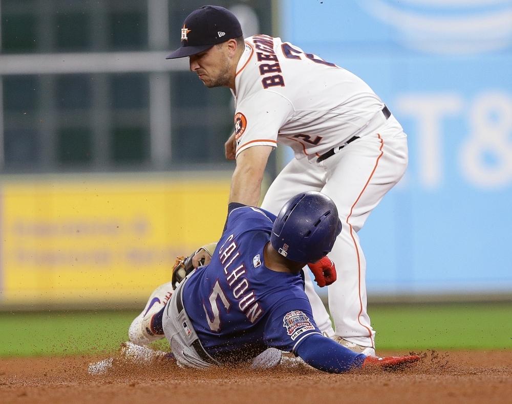 Alex Bregman No. 2 of the Houston Astros tags out Willie Calhoun No. 5 of the Texas Rangers attempting to steal second base at Minute Maid Park on Wednesday in Houston, Texas. — AFP