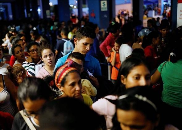 Venezuelan migrants queue at the Ecuadorian-Peruvian border service center to process their documents and be able to continue their journey, on the outskirts of Tumbes, Peru, June 14, 2019.
