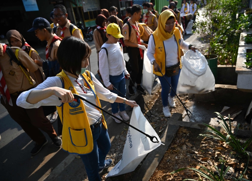 Volunteers pick up trash, such as plastics and cigarrette butts, during world cleanup day campaign in Jakarta, on Saturday. -AFP