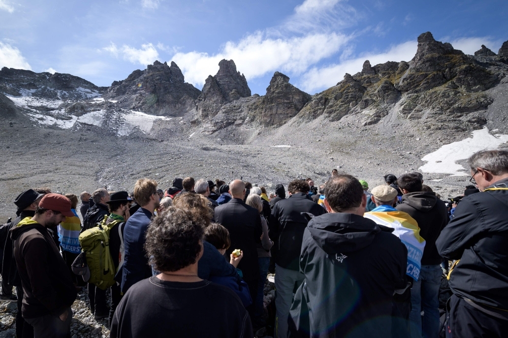 People take part in a ceremony to mark the 'death' of the Pizol glacier (Pizolgletscher) on Sunday above Mels, eastern Switzerland. In a study earlier this year, researchers of ETH technical university in Zurich determined that more than 90 percent of Alpine glaciers will disappear by 2100 if greenhouse gas emissions are left unchecked. — AFP