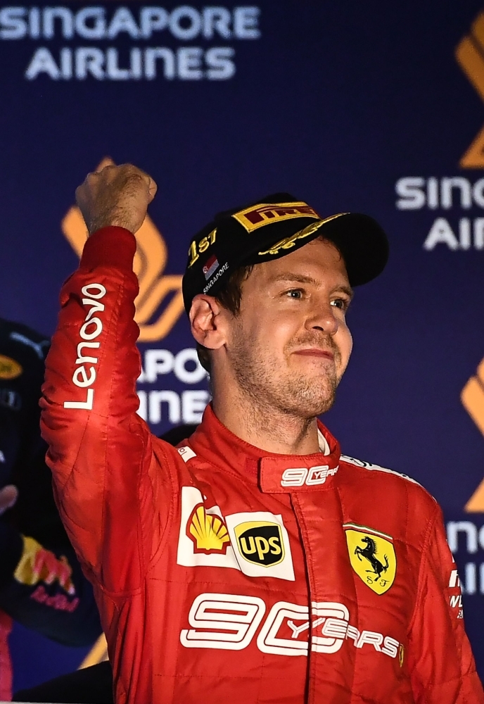 Ferrari's German driver Sebastian Vettel celebrates his victory after the Formula One Singapore Grand Prix night race at the Marina Bay Street Circuit in Singapore, on Sunday. — AFP