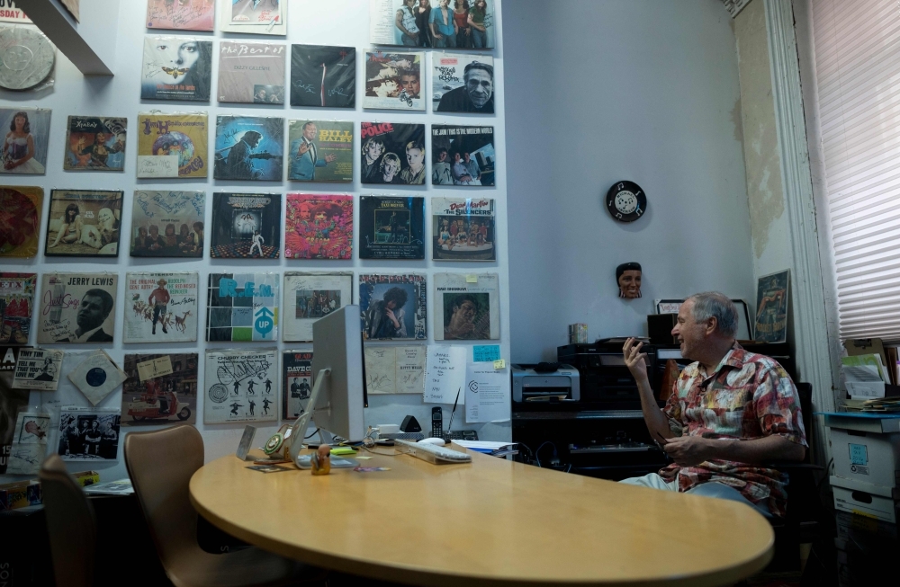 In this file photo Bob George, the Co-Founder and Director of the ARChive of Contemporary Music, points to a poster of the Jimi Hendrix Experience  in New York City. The turntable needle drops and the reverbs of the obscure band The Motifs ring out, bouncing off mountains of records lining the musty warehouse housing America's largest pop music collection.The cavernous independent private music library, known as the ARChive of Contemporary Music, on a non-descript street in lower Manhattan's Tribeca neighborhood claims more than three million recordings — mostly vinyl and some CDS and cassettes, not to mention a vast collection of memorabilia.  — AFP