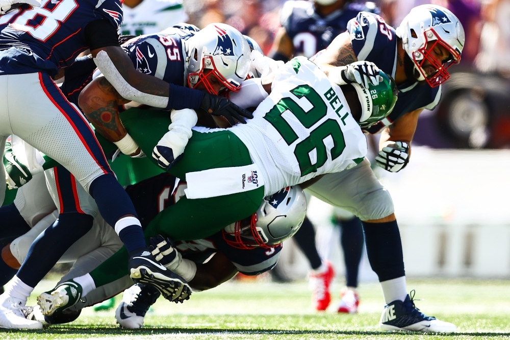 Le'Veon Bell No. 26 of the New York Jets is tackled by multiple New England Patriots during a game at Gillette Stadium on Sunday in Foxborough, Massachusetts. — AFP
