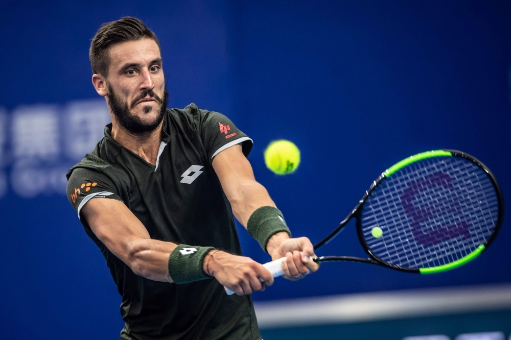 Damir Dzumhur of Bosnia hits a return against Adrian Mannarino of France during their men's singles quarterfinal match at the Zhuhai Championships tennis tournament in Zhuhai in China's southern Guangdong province on Friday. — AFP