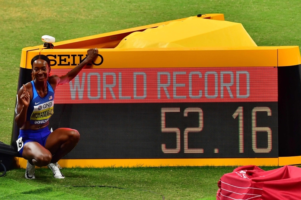 USA's Dalilah Muhammad celebrates after winning and poses next to the screen reading the new world record in the Women's 400m Hurdles final at the 2019 IAAF Athletics World Championships at the Khalifa International stadium in Doha on Friday. — AFP