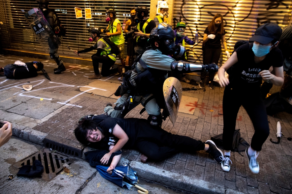 Riot police officers clash with anti-government protesters during a demonstration in Causeway Bay district in Hong Kong on Sunday. -Reuters