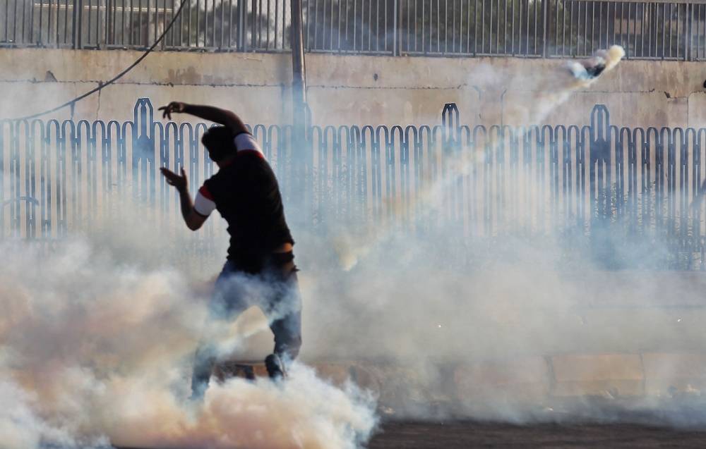An Iraqi demonstrator gestures amidst smoke from burning tires and tear gas during a demonstration against state corruption, failing public services and unemployment, in the Iraqi capital Baghdad, in this Oct. 5, 2019 file photo. — AFP