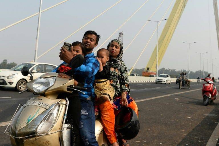 An Indian man takes a selfie with his family on a scooter on the newly-built Signature Bridge in New Delhi in this Nov. 15, 2018 file photo. — AFP
