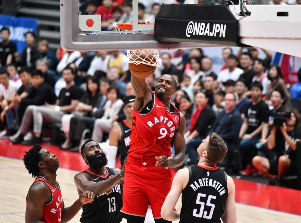 Toronto Raptors Serge Ibaka (C) dunks the ball against Houston Rockets in their NBA preseason basketball game in Saitama, on Tuesday. — AFP