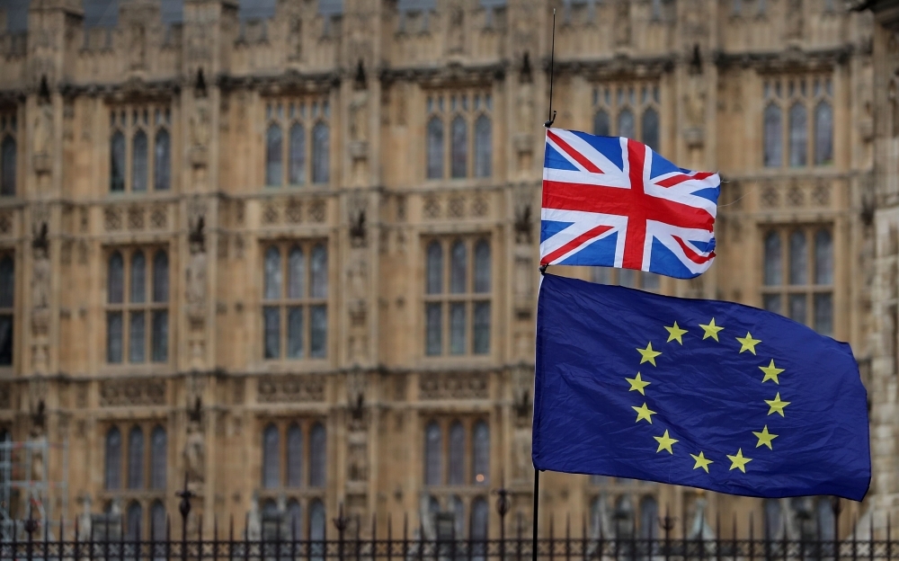 An anti-Brexit activist waves a Union and a European Union flag as they demonstrate outside the Houses of Parliament in central London in this Jan. 23, 2019 file photo. — AFP