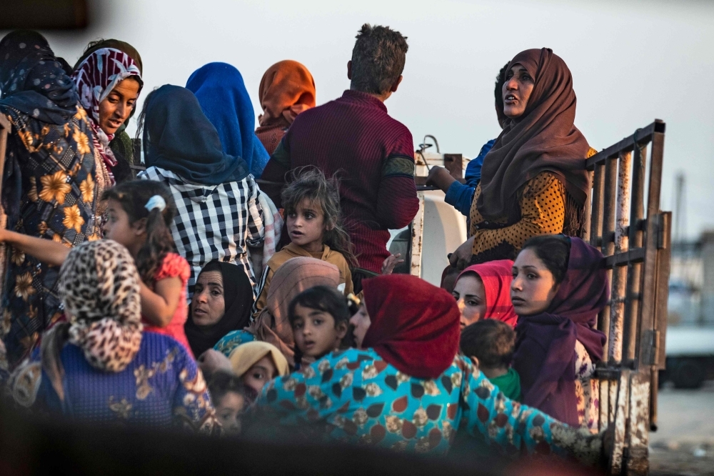 Civilians flee amid Turkish bombardment on Syria's northeastern town of Ras Al-Ain in the Hasakeh province along the Turkish border on Wednesday. — AFP