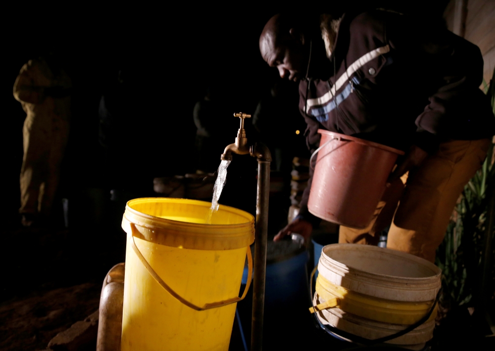 Residents collect water at night from an electric-powered borehole, as the country faces 18-hour daily power cuts, in a suburb of Harare, Zimbabwe, in this July 30, 2019 file photo. — Reuters