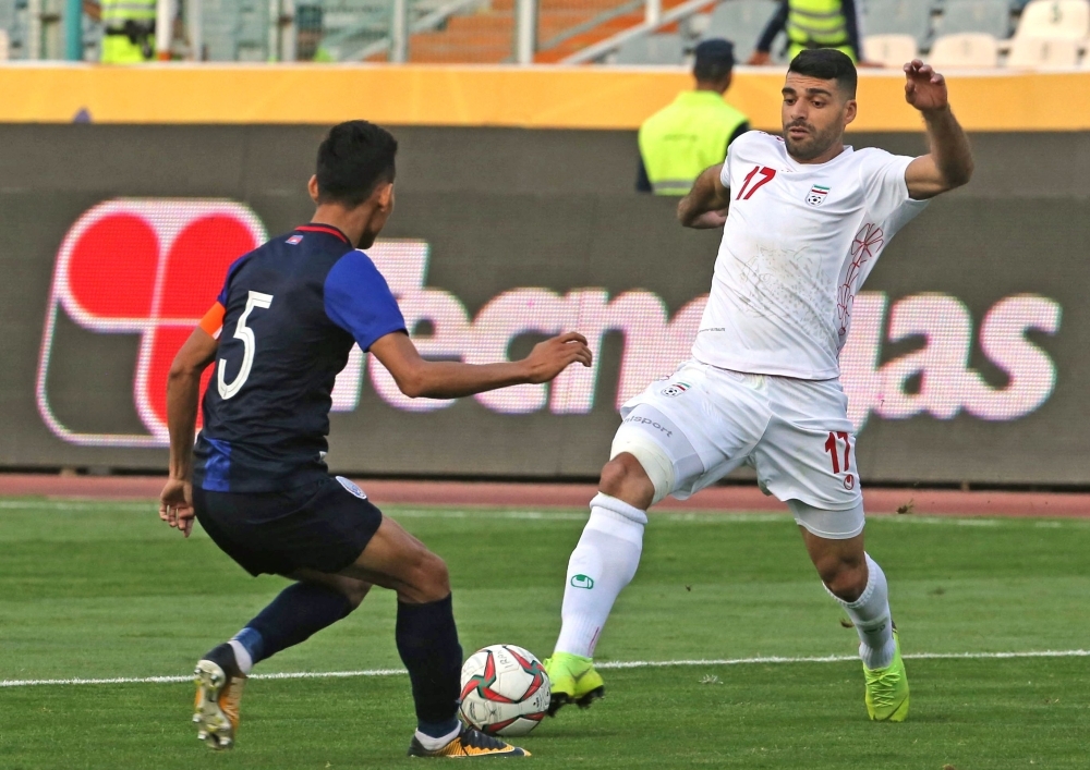 Iran's forward Mehdi Taremi (R) vies for the ball with Cambodia's defender Soeuy Visal (L) during the World Cup Qatar 2022 Group C qualification football match between Iran and Cambodia at the Azadi stadium in the capital Tehran on Thursday. — AFP
